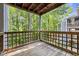 This balcony shows a lattice wood railing and a view to the forest in the background at 4631 Timbermill Ct # 203, Raleigh, NC 27612