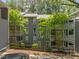 Three-story condominium building surrounded by mature trees, landscaping and covered patios at 4631 Timbermill Ct # 203, Raleigh, NC 27612