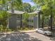 Three-story gray condo building featuring wood trim, a parking lot, and surrounded by mature trees at 4631 Timbermill Ct # 203, Raleigh, NC 27612