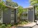 Well-maintained three-story gray condo building surrounded by mature trees and landscaping at 4631 Timbermill Ct # 203, Raleigh, NC 27612