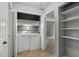 Laundry area with a washing machine, dryer, storage shelves, and tile flooring at 4631 Timbermill Ct # 203, Raleigh, NC 27612