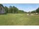 Spacious backyard with a lush lawn, black metal fence, and mature trees at 475 Long View Dr, Franklinton, NC 27525