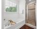 Bright bathroom featuring a large window over tub and glass enclosed tiled shower at 475 Long View Dr, Franklinton, NC 27525