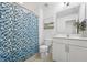 Well-lit bathroom featuring a blue patterned shower curtain and a clean white vanity at 475 Long View Dr, Franklinton, NC 27525