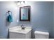 Powder room featuring a sleek vanity, mirror, and soft blue walls at 5016 Dawn Piper Dr, Raleigh, NC 27613