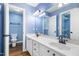 Bathroom featuring double sinks, white cabinets, and modern lighting fixtures at 5016 Dawn Piper Dr, Raleigh, NC 27613