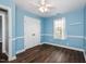 Blue bedroom with hardwood floors, a window and a double-door closet at 5016 Dawn Piper Dr, Raleigh, NC 27613
