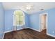Bright bedroom with an arch window, fan, and wood floors at 5016 Dawn Piper Dr, Raleigh, NC 27613