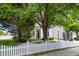 Charming two-story home with white siding, black shutters, and a well-manicured front yard and a white picket fence at 5016 Dawn Piper Dr, Raleigh, NC 27613