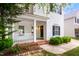 Inviting front porch with white columns, brick accents, and a stylish black front door with sidelight windows at 5016 Dawn Piper Dr, Raleigh, NC 27613