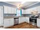 The kitchen showcases stainless steel appliances, white cabinets, and a view of the outdoors at 5016 Dawn Piper Dr, Raleigh, NC 27613