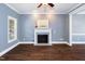 Bright living room featuring hardwood floors, fireplace, and open access to the dining area at 5016 Dawn Piper Dr, Raleigh, NC 27613