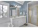 Bathroom featuring striped wallpaper, white cabinets, and a glass-enclosed shower at 511 Windstream Way, Cary, NC 27518