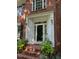 Charming brick home entrance features decorative white trim, sidelights, transom window and manicured plants at 511 Windstream Way, Cary, NC 27518