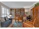 Cozy living room with hardwood floors, large bookshelves, and ample seating for relaxation and entertaining at 511 Windstream Way, Cary, NC 27518
