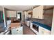 Kitchen features a backsplash, white cabinets, wooden floating shelves, and stainless appliances at 55 Livingston Ln, Spring Hope, NC 27882
