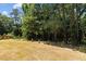A spacious backyard is lined by trees and trimmed bushes at 5601 Preston Pl, Raleigh, NC 27604
