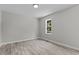 Bright bedroom with wood-look flooring and a window showcasing the outdoors at 5601 Preston Pl, Raleigh, NC 27604