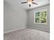 Neutral bedroom with a ceiling fan, carpet, and a window providing natural light at 5601 Preston Pl, Raleigh, NC 27604