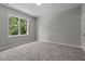 Carpeted bedroom with a large window showcasing a green, wooded landscape at 5601 Preston Pl, Raleigh, NC 27604