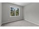 Carpeted bedroom with a large window framing a view of trees and the sky at 5601 Preston Pl, Raleigh, NC 27604