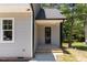 Charming home entrance with gray siding, black door, and small porch at 5601 Preston Pl, Raleigh, NC 27604