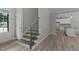 Bright entryway featuring wood-look floors, modern staircase, and an open view into the kitchen at 5601 Preston Pl, Raleigh, NC 27604