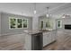 Modern kitchen island with stainless steel dishwasher and sink, with views of living and dining area at 5601 Preston Pl, Raleigh, NC 27604