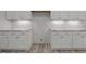White shaker cabinets with stone countertops and undermount lighting are featured in this kitchen view at 5601 Preston Pl, Raleigh, NC 27604