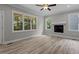 Living room showcasing a modern fireplace, a ceiling fan, recessed lights, and large windows at 5601 Preston Pl, Raleigh, NC 27604
