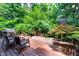 Inviting backyard deck with a grill, seating area, and lush landscaping offers a private outdoor retreat at 574 Chatham Dr, Chapel Hill, NC 27516