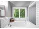 Bright bathroom with a soaking tub near a window offering peaceful views, complemented by white subway tile at 574 Chatham Dr, Chapel Hill, NC 27516