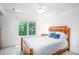 Bedroom with a wooden bedframe, blue throw pillows, and a sunlit window with backyard views at 574 Chatham Dr, Chapel Hill, NC 27516