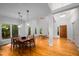 Bright dining room with hardwood floors, a modern dining table, and multiple windows offering verdant views at 574 Chatham Dr, Chapel Hill, NC 27516