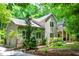 Two-story home with meticulous landscaping and a charming covered porch, all nestled in a serene, wooded environment at 574 Chatham Dr, Chapel Hill, NC 27516