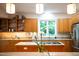 Well-lit kitchen showcasing custom wood cabinets, granite countertops, and stainless steel appliances at 574 Chatham Dr, Chapel Hill, NC 27516