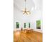 Spacious living room with hardwood floors, large windows, and a vaulted ceiling at 574 Chatham Dr, Chapel Hill, NC 27516