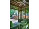 Covered patio with ceiling fan, lounge chairs, and a view of the backyard deck and lush surroundings at 574 Chatham Dr, Chapel Hill, NC 27516