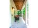 Inviting covered porch with brick flooring, comfortable seating, and a view of the surrounding greenery at 574 Chatham Dr, Chapel Hill, NC 27516