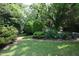 Lush backyard with mature trees, green lawn and verdant landscaping, offering a serene outdoor space at 582 Wimbleton Dr, Raleigh, NC 27609