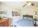 Bedroom with a ceiling fan, hardwood floors, neutral paint, and a large window providing natural light at 582 Wimbleton Dr, Raleigh, NC 27609