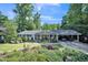 Charming home exterior with lush landscaping, mature trees, and a well-manicured lawn at 582 Wimbleton Dr, Raleigh, NC 27609