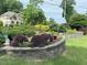 Landscaped front yard featuring stone retaining walls, vibrant shrubs, and green grass at 582 Wimbleton Dr, Raleigh, NC 27609