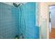 Bright blue tiled shower with a shower head and view of bathroom with classic finishes at 582 Wimbleton Dr, Raleigh, NC 27609