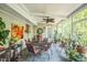 Inviting sunroom with tiled floor, fan, floral decorations, and many plants at 582 Wimbleton Dr, Raleigh, NC 27609