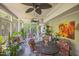 Cozy sunroom featuring tiled floor, ceiling fans, plants, and ample seating at 582 Wimbleton Dr, Raleigh, NC 27609