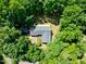 An aerial shot captures the home surrounded by lush green trees, enhancing the property's sense of privacy and natural beauty at 5822 Country Lane Dr, Durham, NC 27705