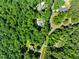 An aerial photograph reveals the residence nestled within a neighborhood enveloped by abundant trees and a winding road at 5822 Country Lane Dr, Durham, NC 27705