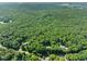 An aerial perspective reveals the home set amidst a densely wooded area, showcasing the tranquility and privacy of the surroundings at 5822 Country Lane Dr, Durham, NC 27705