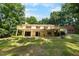 Backyard view of home showing a large deck with stairs, and lush landscaping at 5822 Country Lane Dr, Durham, NC 27705